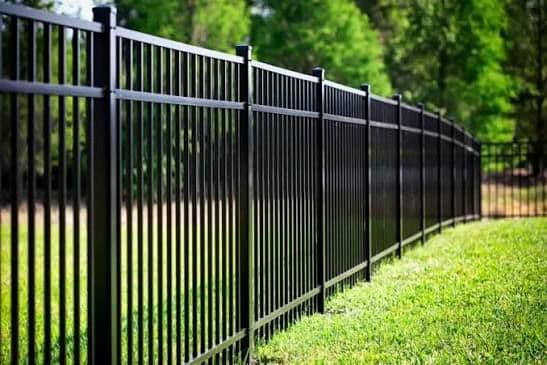 Long run of black aluminum fence with pristine landscape