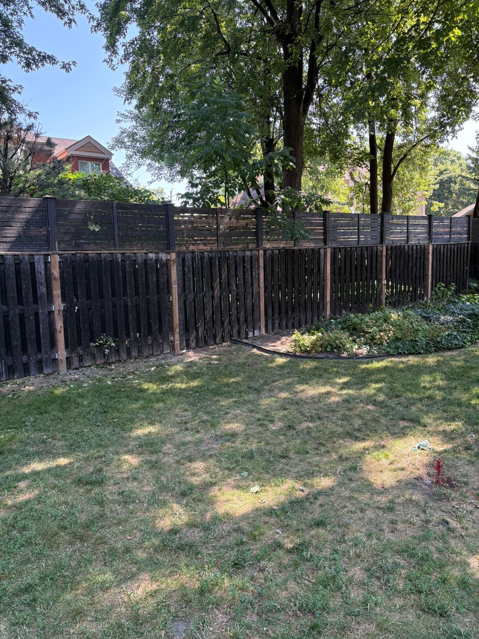 Wood fence with storm damage and debris removal