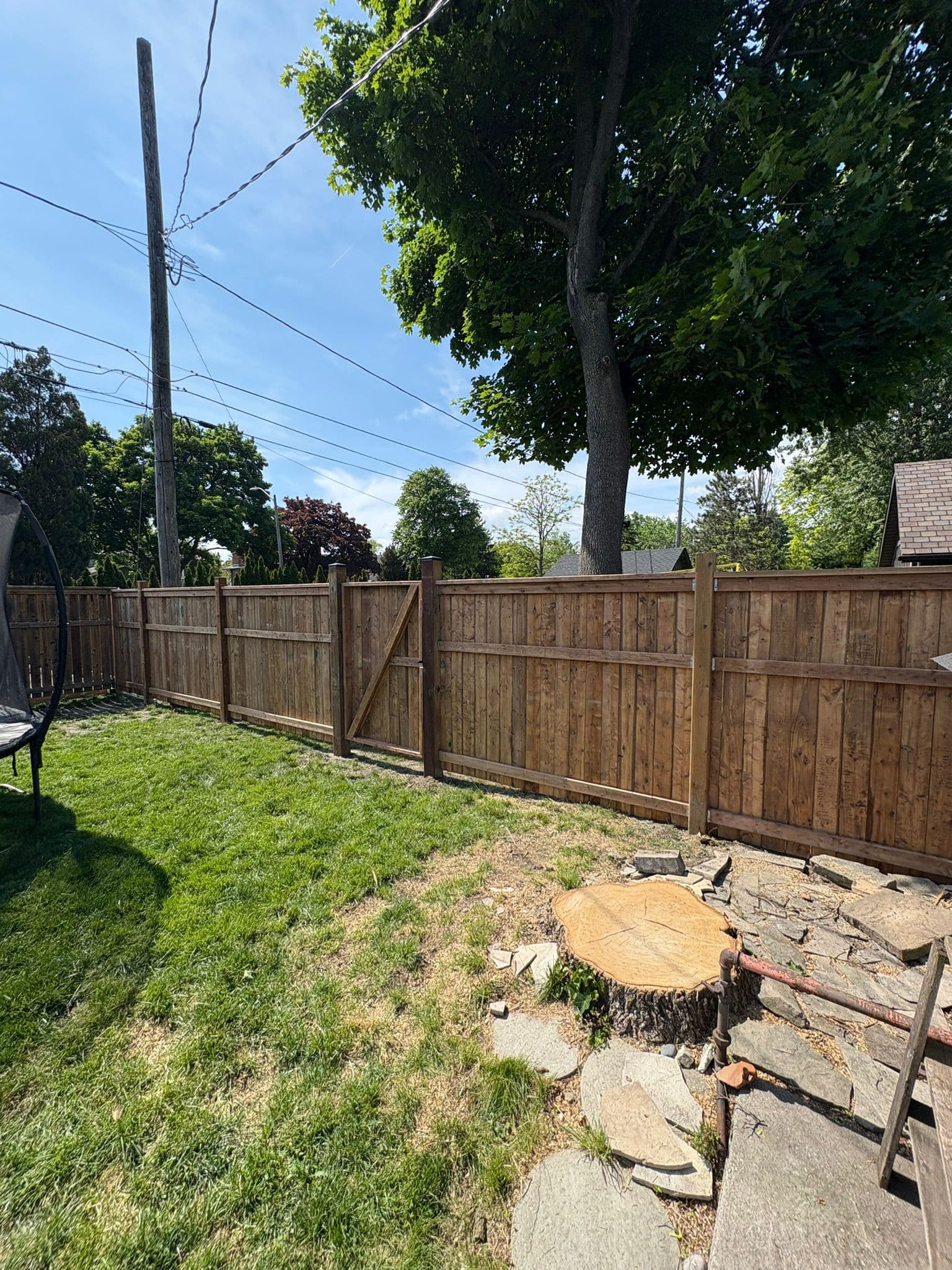 Vertical board wood fence with gate in residential yard