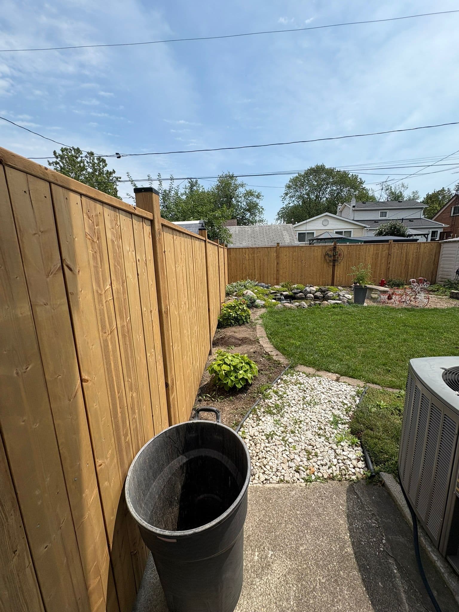 Wood privacy fence along residential property with landscaping