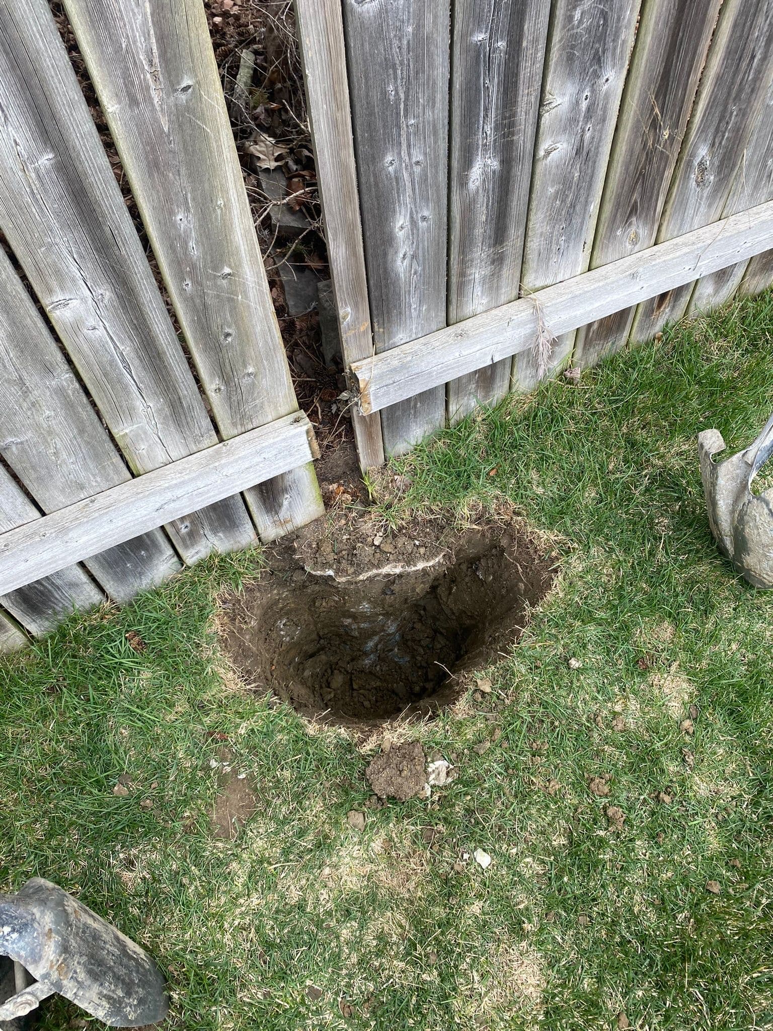 Wood fence with visible post damage and ground erosion