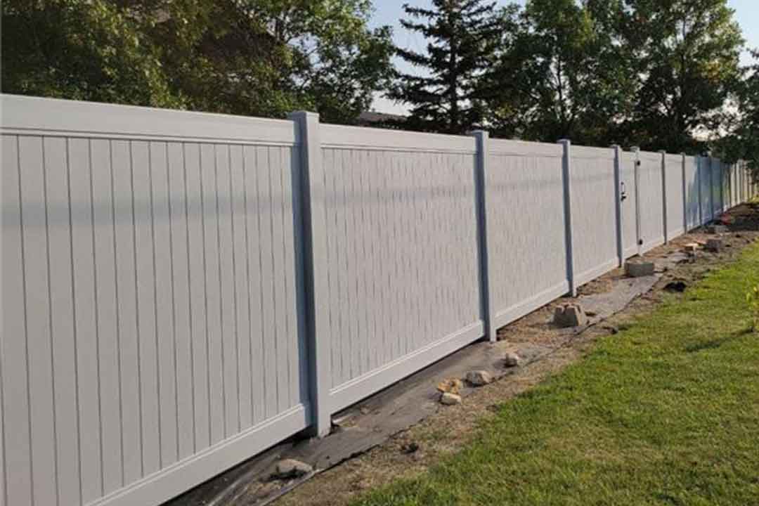 White vinyl privacy fence with landscaping